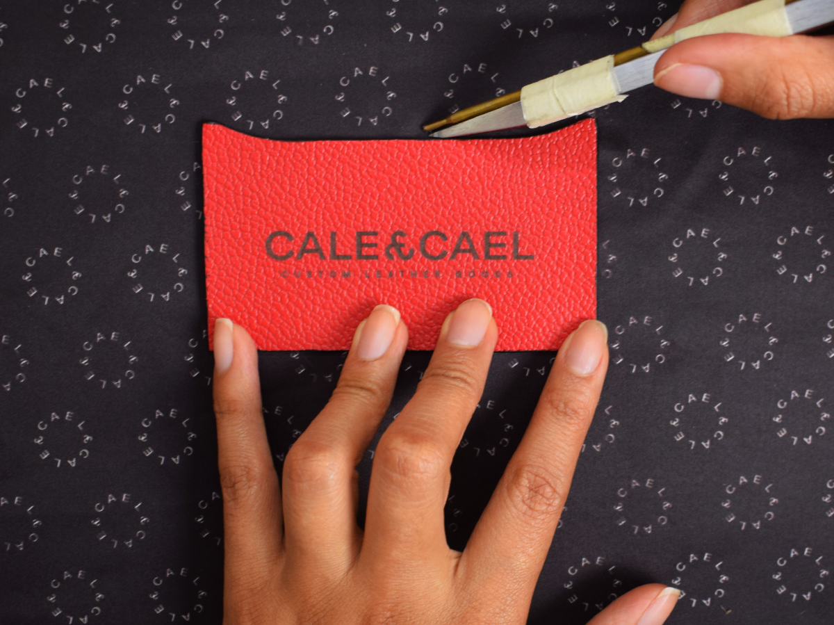 Artisans' hands crafting a leather suitcase